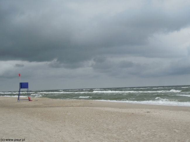 Plaża w pochmurny dzień, czerwona flaga