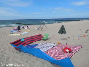 Rozłożone koce i parawany na plaży bez ludzi