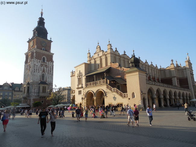 Arkadowy, biały budynek Sukiennic obok samotna wieża