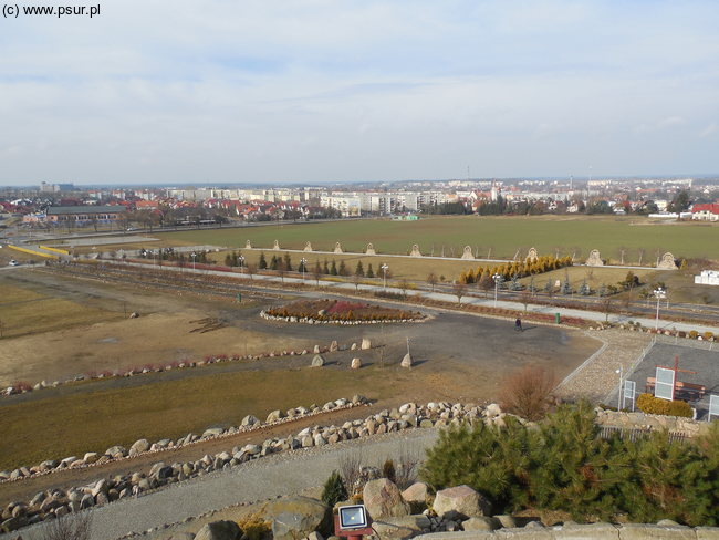 Widok z góry na plac z parkingiem, w oddali Świebodzin