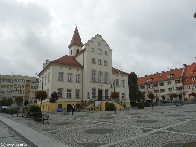 Brukowany plac - rynek, a na środku ratusz